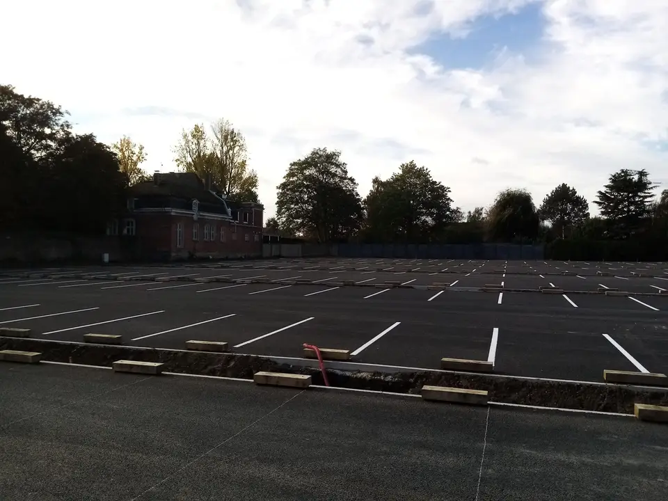 Grand parking aux places délimitées par un marquage blanc